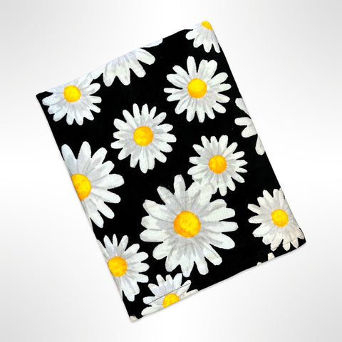 Large personalised beach towel with white and grey flowers on a black background.
