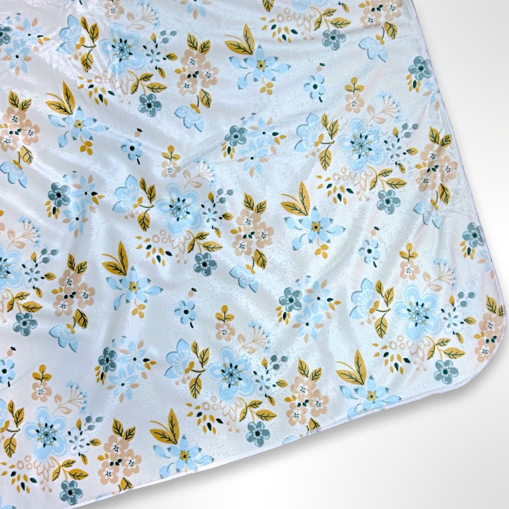 Double layer minky fleece blanket with dainty blue flowers with light brown accents on a white background ready to be personalised with an embroidered name