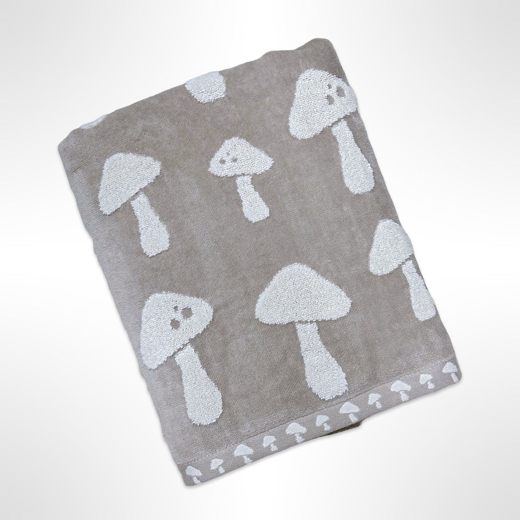 Personalised bath towel that has white mushrooms on a taupe background.