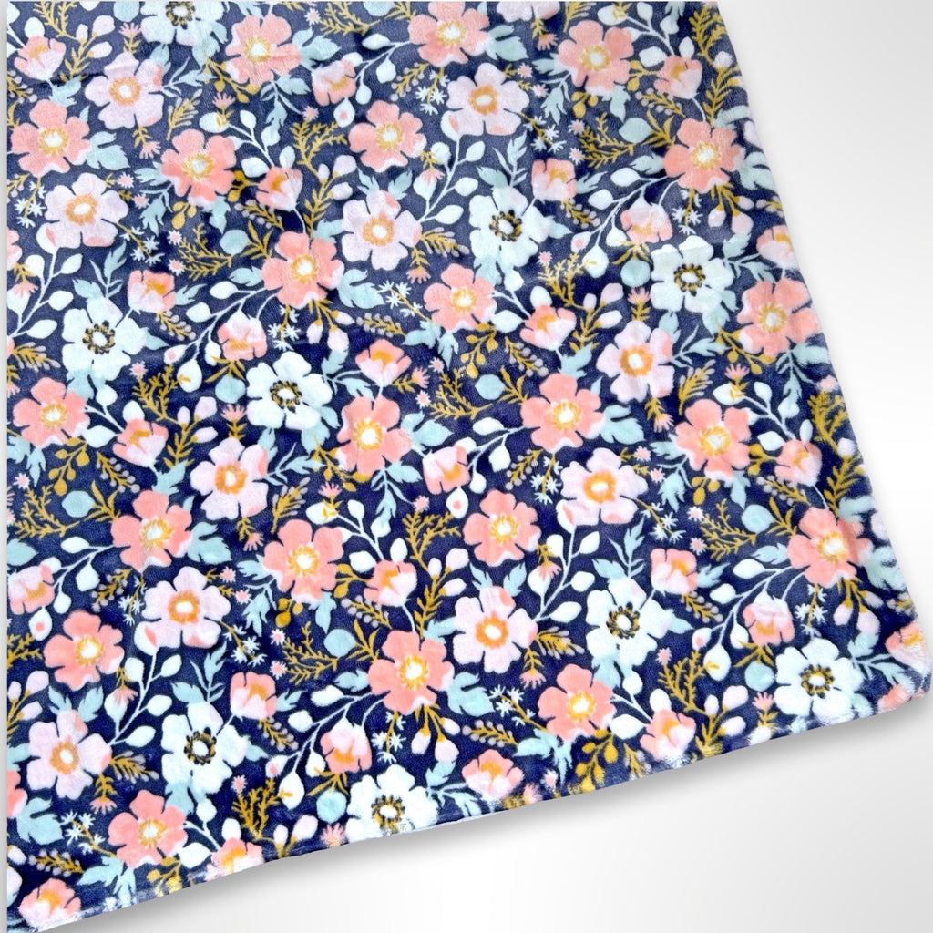 Double layer minky fleece blanket with peach, pink and mint flowers on a navy background ready to be personalised with an embroidered name
