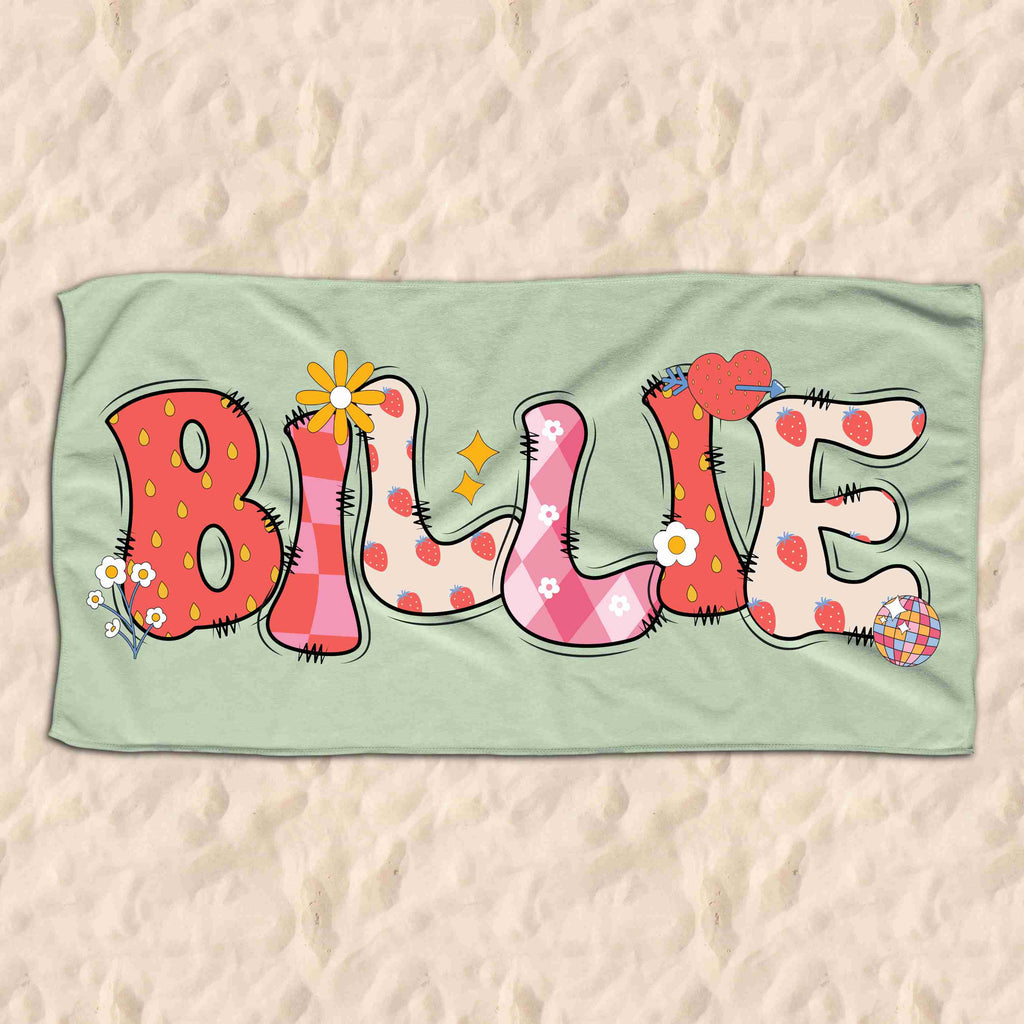 Light green childrens beach towel personalised with the name Billie in a groovy strawberry font