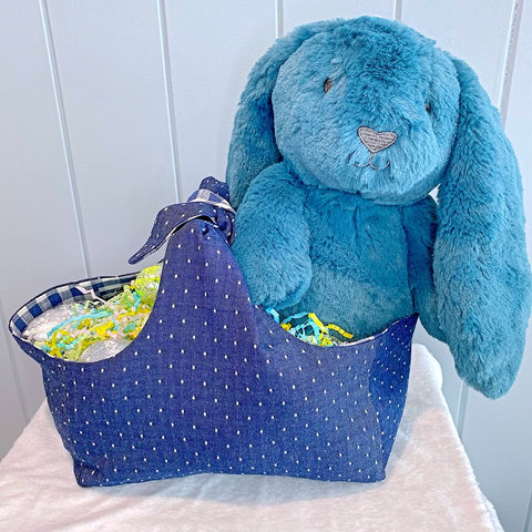 Handmade personalised easter basket bag with outer layer made out of denim blue and white spot fabric and inner lining in a blue and white gingham check fabric.