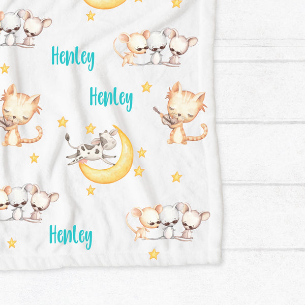 Personalised fleece minky blanket with the nursery rhyme characters of the cat playing the fiddle in hey diddle diddle, the cow jumping over the moon and three blind mice