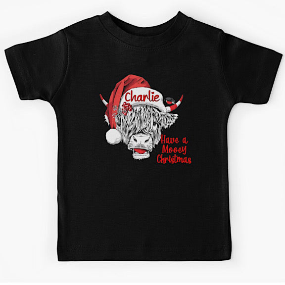 Black short sleeved tshirt with face of black and white highland cow wearing a Christmas Santa Hat personalised with a name