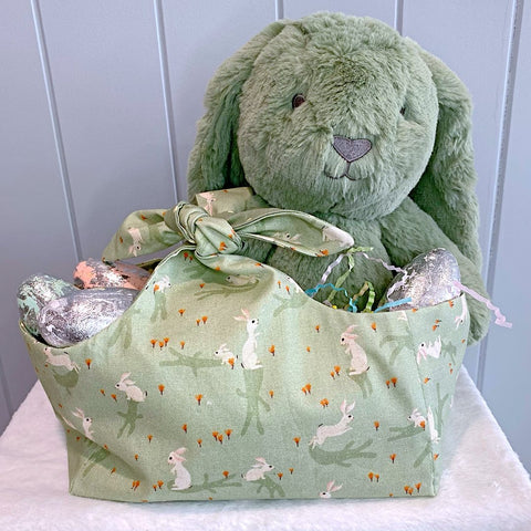 Handmade personalised easter basket bag with outer layer made out of white bunnies on a sage green background fabric and inner lining in a sage and white spot fabric.