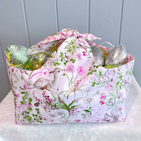 Handmade personalised easter basket bag with outer layer made out of woodland creatures on a white background fabric and inner lining in a pink white and green spot fabric.