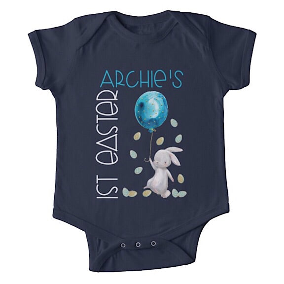 Short sleeved dark blue baby onesie for a first easter with a white bunny tiptoeing through Easter eggs personalised with a name