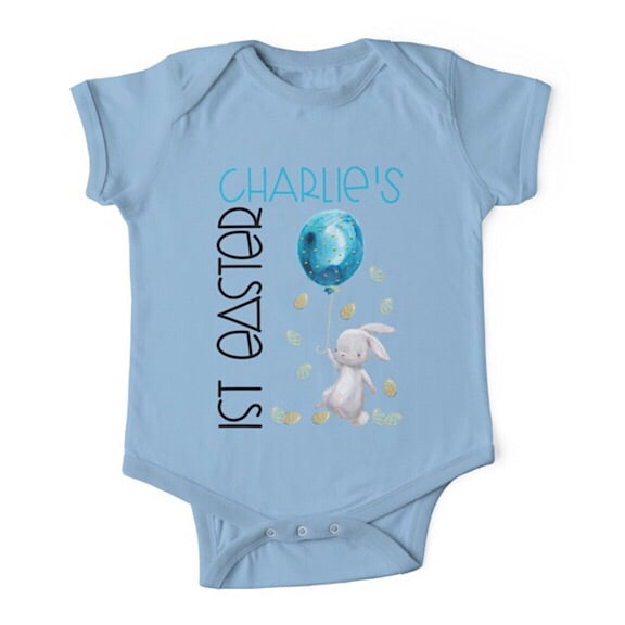 Short sleeved light blue baby onesie for a first easter with a white bunny tiptoeing through Easter eggs personalised with a name