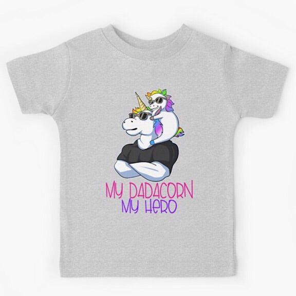Light grey short sleeved kids tshirt with a muscly white father unicorn wearing a black tshirt with a baby unicorn on his shoulders with the words my dadacorn my hero underneath