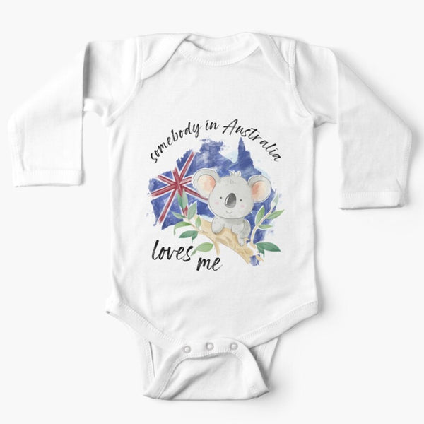 White long sleeved onesie with somebody in Australia loves you written in cursive text around the picture of a grey koala sitting on the branch of a gumtree on the background of the australian flag