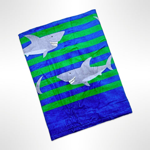 Large personalised beach towel with happy grey sharks on a blue and green striped background.