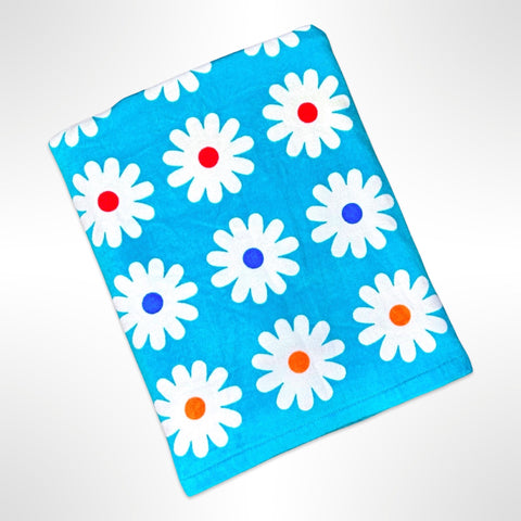 Large personalised beach towel that has an aqua blue background with white flowers in rows with different coloured centres.