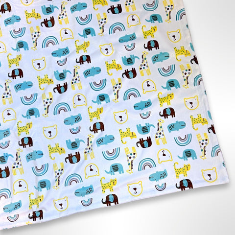 Minky blanket with blue, yellow and brown animals such as hippos, giraffes, tigers, bears and elephants among rainbows on a white background, ready to be personalised with a name in embroidery