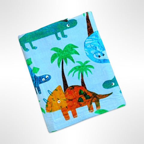 Children's personalised beach towel with various dinosaurs drawn in a child-like manner among palm trees on an aqua blue background.