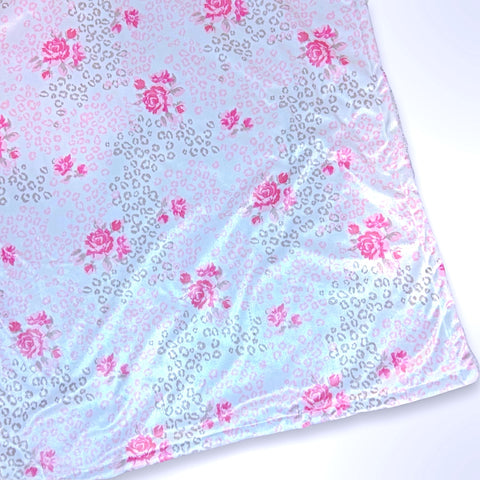Double layer minky fleece blanket with pink flowers among leopard spots on a white background ready to be personalised with an embroidered name.