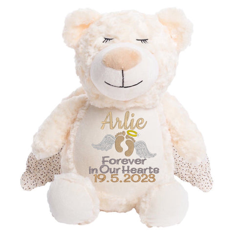 Cream coloured plush angel teddy bear with sleeping eyes and angel wings on the back, personalised with embroidery that has name of deceased, date of death and the words Forever in Our Hearts, along with embroidered angel wings and halo