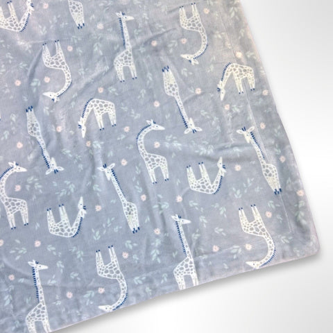 Minky blanket with grey and white giraffes among green leaves and pink flowers on a grey background, ready to be personalised with a name in embroidery 