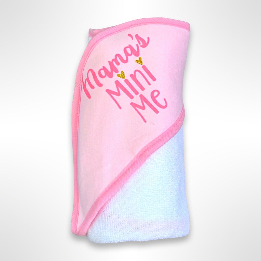 White personalised baby hooded towel - the hood is pink with the words Mam'a's Mini Me written in pink.