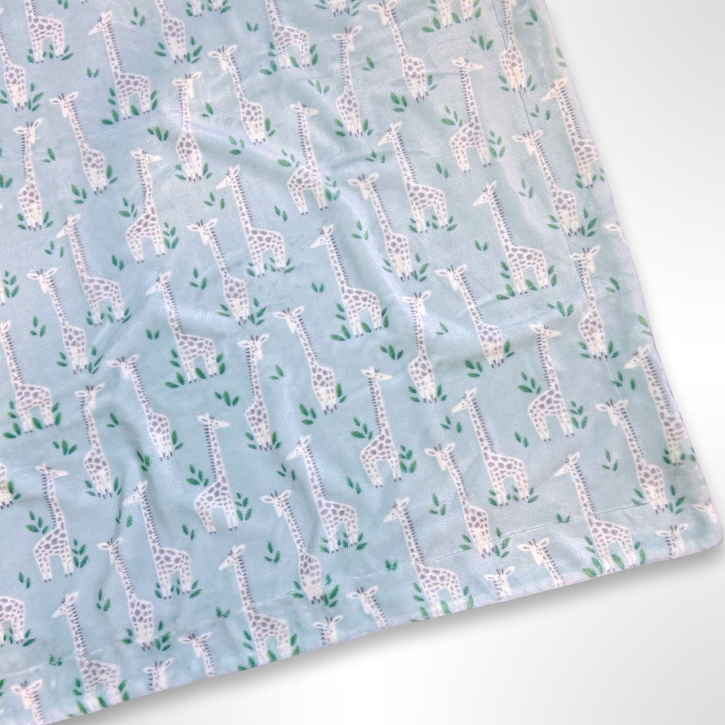 Minky blanket with grey and white giraffes among green leaves on a mint coloured background, ready to be personalised with a name in embroidery
