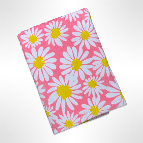 Personalised Children's Beach Towel with white and yellow daisy like flowers on a peach coloured background.