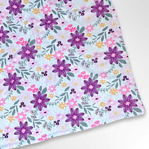 Minky blanket with bright pink and purple flowers on a white background, ready to be personalised with a name in embroidery
