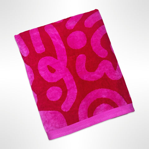 Large personalised beach towel that has lighter pink squiggle marks on top of a darker pink background.