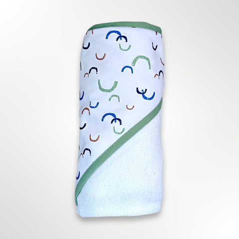 White personalised baby hooded towel. The hood has a green, blue and brown rainbow pattern.