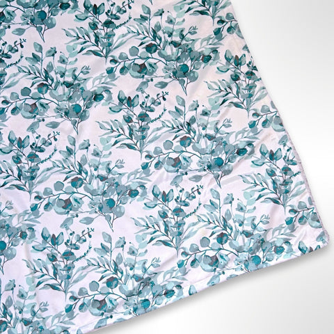 Minky blanket with sage green floral foliage on a white background, ready to be personalised with a name in embroidery
