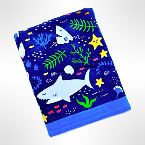 Childrens personalised beach towel that has sharks, fish and other underwater plants on a navy background.