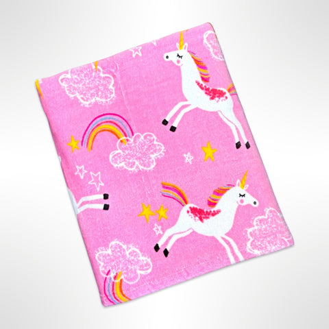 Children's personalised beach towel with white unicorns dancing among the white clouds and bright coloured rainbows, all on a candy pink background.