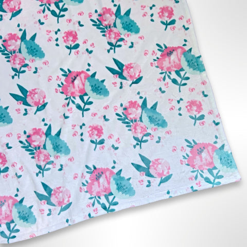 Double layer personalised minky blanket with pink and mint green flowrers on a light pink background, ready to be personalised with a name using embroidery.