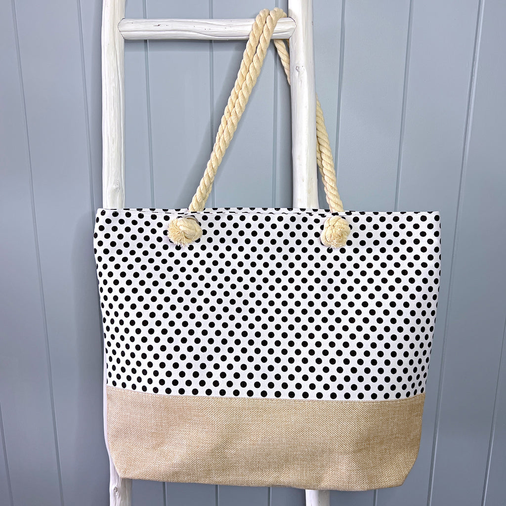 Personalised beach bag/ tote bag hanging from a white timber ladder using its rope handle. The white bag is covered in small black spots.