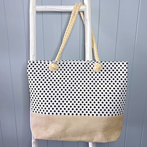 Personalised beach bag/ tote bag hanging from a white timber ladder using its rope handle. The white bag is covered in small black spots.
