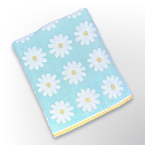 Light blue personalised bath towel with white and yellow daisies.