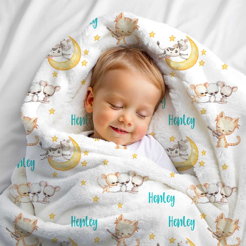Blonde haired boy wrapped up in a personalised minky blanket. The minky blanket has nursery rhyme characters printed on it along with the name Henley.
