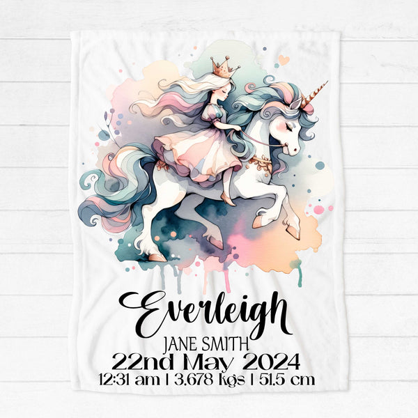A white minky blanket on a white floorboard background. The blanket has a picture of a princess riding a unicorn in pastel watercolour shades. The blanket is personalised with birth details including name, date of birth, time of birth, weight and length at birth.