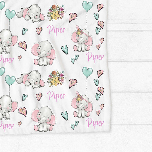 Personalised fleece minky blanket covered in grey floppy eared elephants in a variety of poses with bunches of flowers, pink and mint green hearts and mint green heart balloons