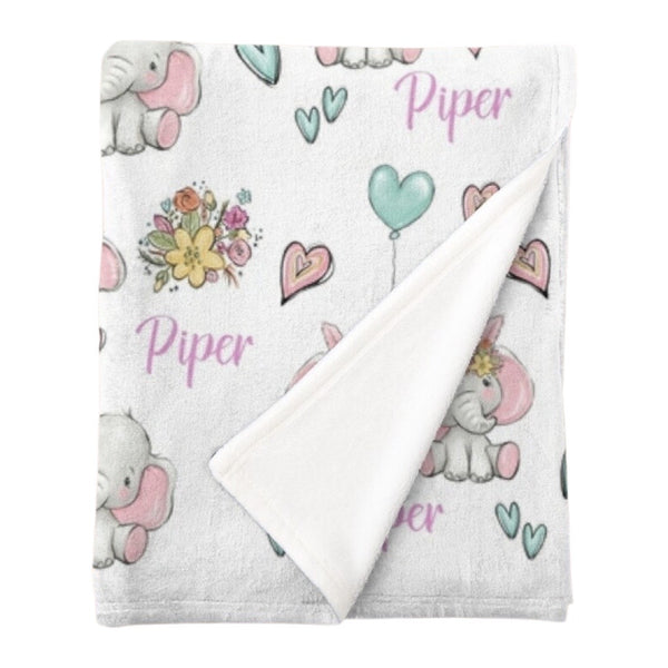 Personalised fleece minky blanket covered in grey floppy eared elephants in a variety of poses with bunches of flowers, pink and mint green hearts and mint green heart balloons