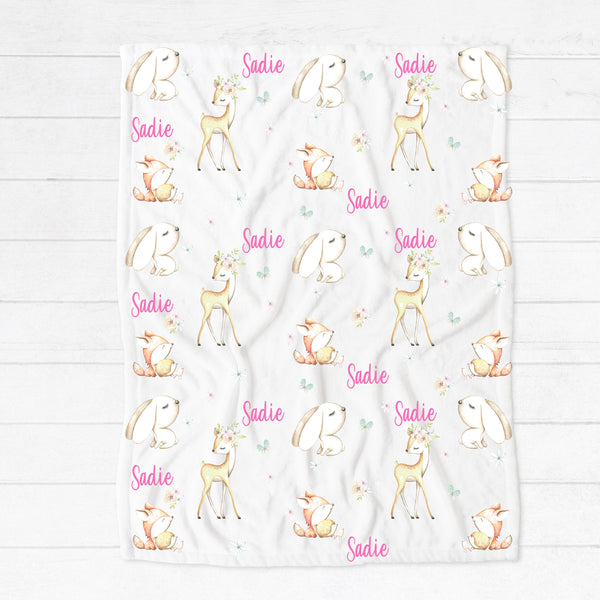 Personalised fleece minky blanket with the forest animals bunny, deer, squirrel, hedgehog and bird among a field of flowers and butterflies