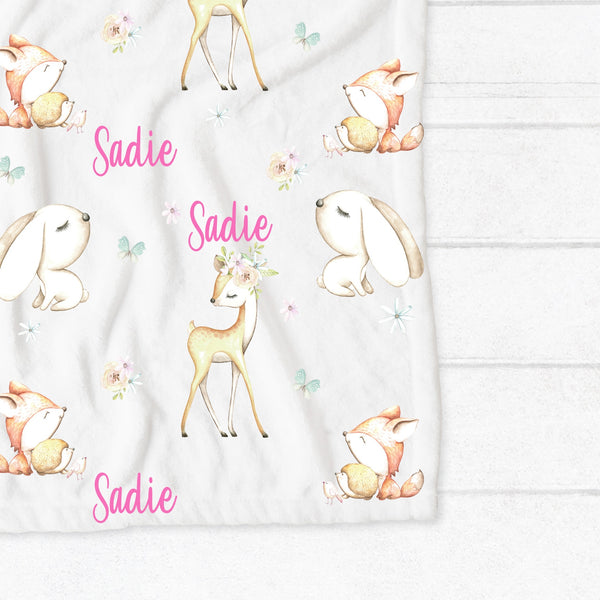 Personalised fleece minky blanket with the forest animals bunny, deer, squirrel, hedgehog and bird among a field of flowers and butterflies