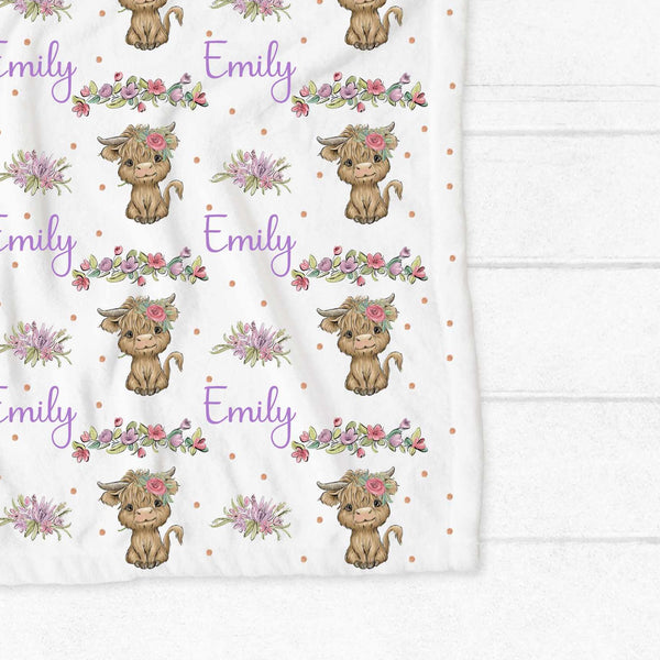 Personalised fleece minky blanket with brown hairy highland cows with a pink flower in the hair and pink and purple blooms interspersed