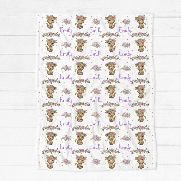 Personalised fleece minky blanket with brown hairy highland cows with a pink flower in the hair and pink and purple blooms interspersed