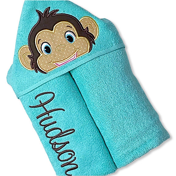 Hooded bath beach swim towel in aqua blue with aqua blue hood. Hood has the face of a happy monkey appliquéd in the centre. Personalised with a name.