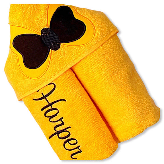 Hooded bath beach swim towel in yellow with yellow hood. Hood has big yellow and black bow appliquéd in the centre. Personalised with a name.