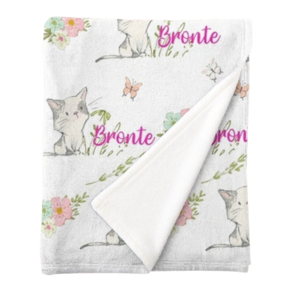 Personalised fleece minky blanket with grey and white kittens playing in a field of pink, blue and white flowers chasing pink and white butterflies