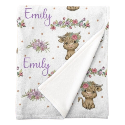 Personalised fleece minky blanket with brown hairy highland cows with a pink flower in the hair and pink and purple blooms interspersed