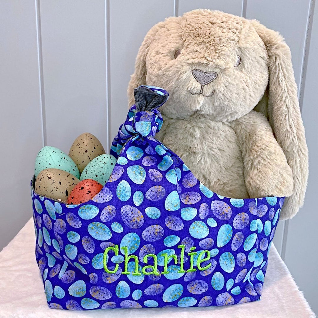 Handmade personalised easter basket bag with outer layer made out of blue speckled eggs on a navy background fabric and inner lining in a grey blue denim fabric.