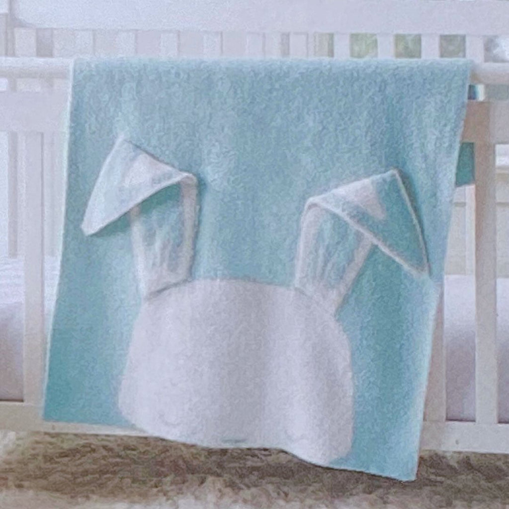 Light blue knit baby blanket with the white face of a bunny at one end with long floppy ears, personalised with a name