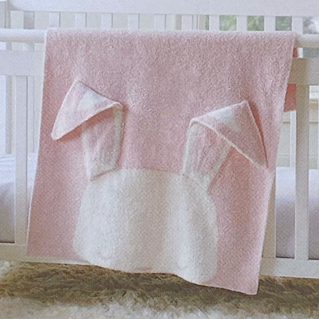 Light pink knit baby blanket with the white face of a bunny at one end with long floppy ears, personalised with a name