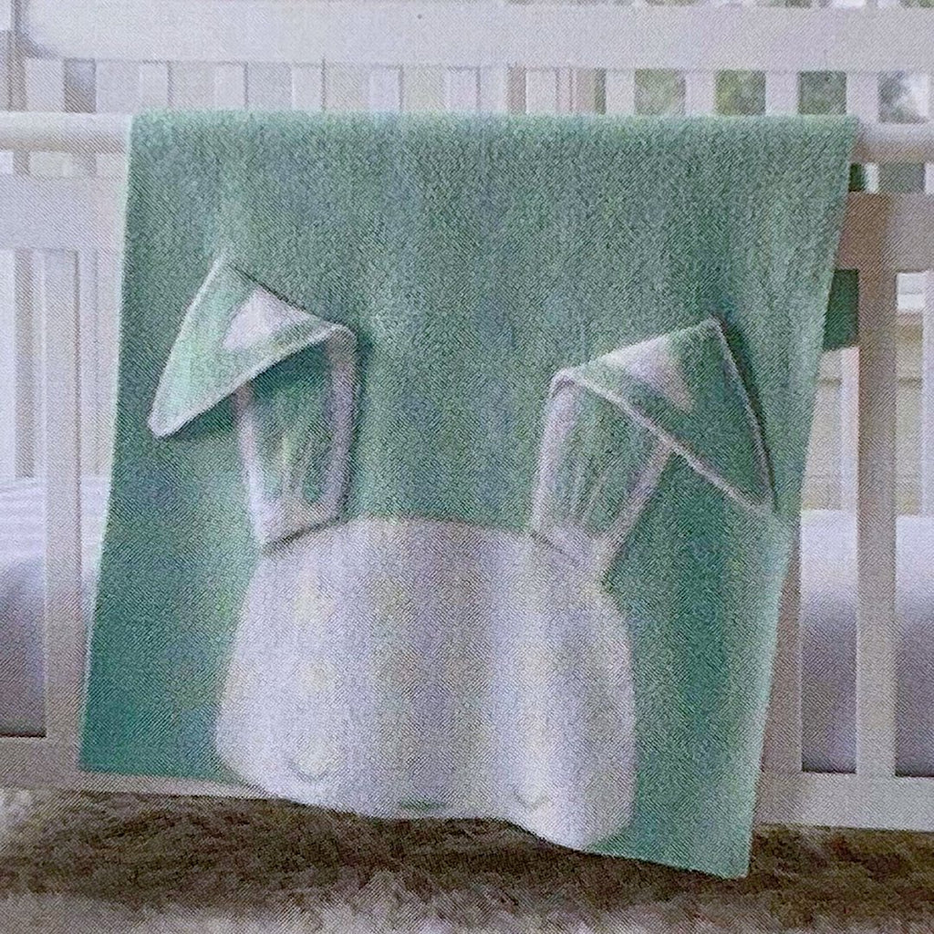 Sage knit baby blanket with the white face of a bunny at one end with long floppy ears, personalised with a name